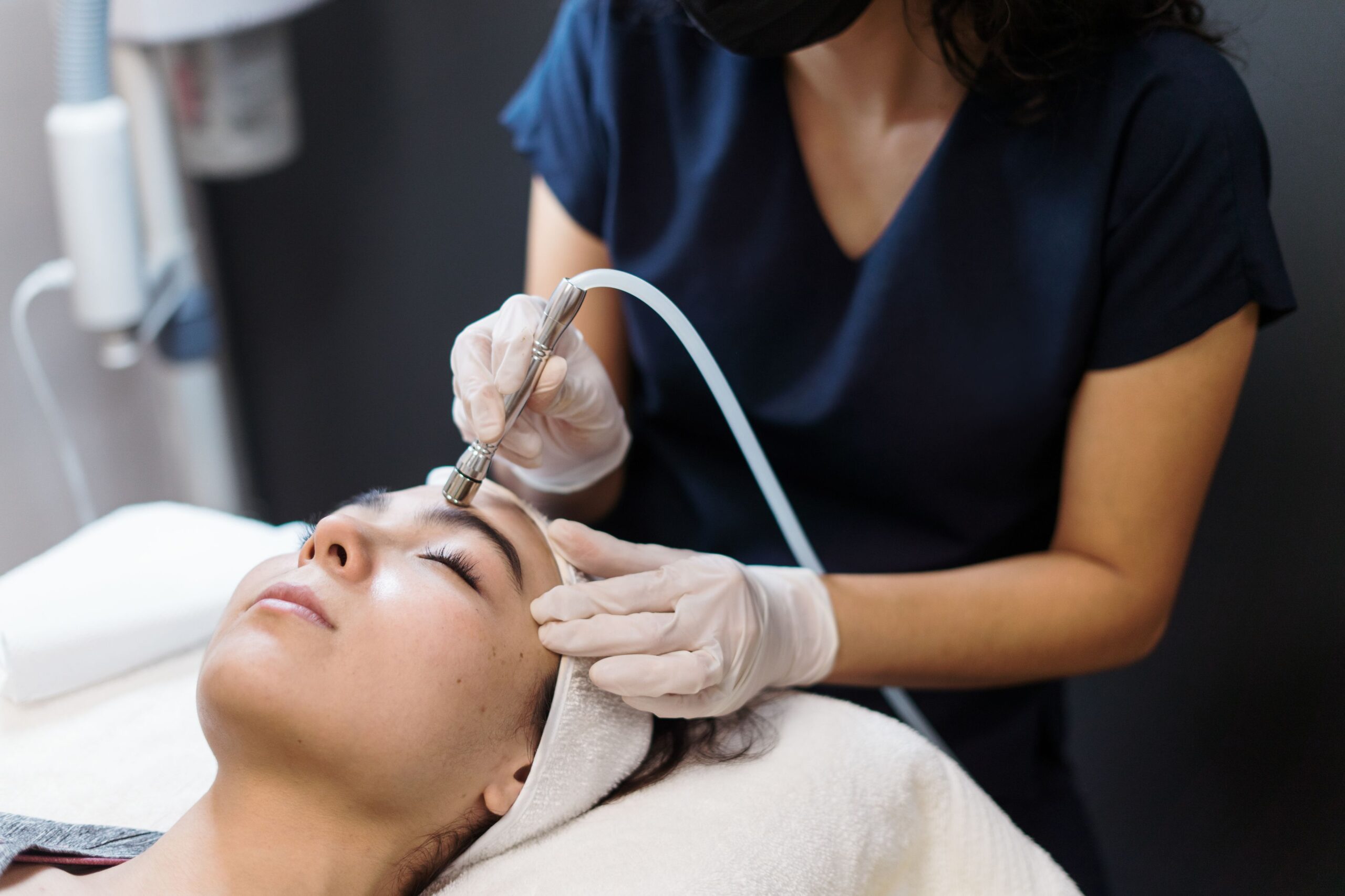 A professional applies the 3D Skin Rejuvenation Treatment on a woman lying on a treatment bed.