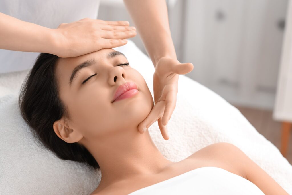 A relaxing Aromatic Facial treatment with hands gently massaging a client's face for ultimate relaxation
