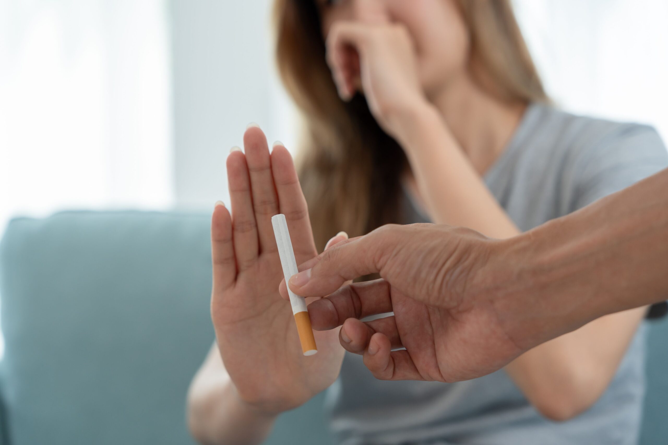 A woman refusing a cigarette with a hand gesture, highlighting the importance of quitting smoking for better health.