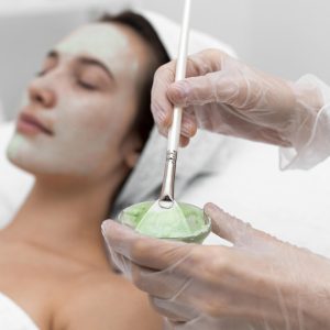 beautician applying face mask female client