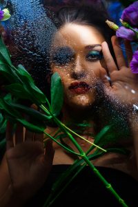 fashion portrait of beautiful girl with bright make up among eustomas.